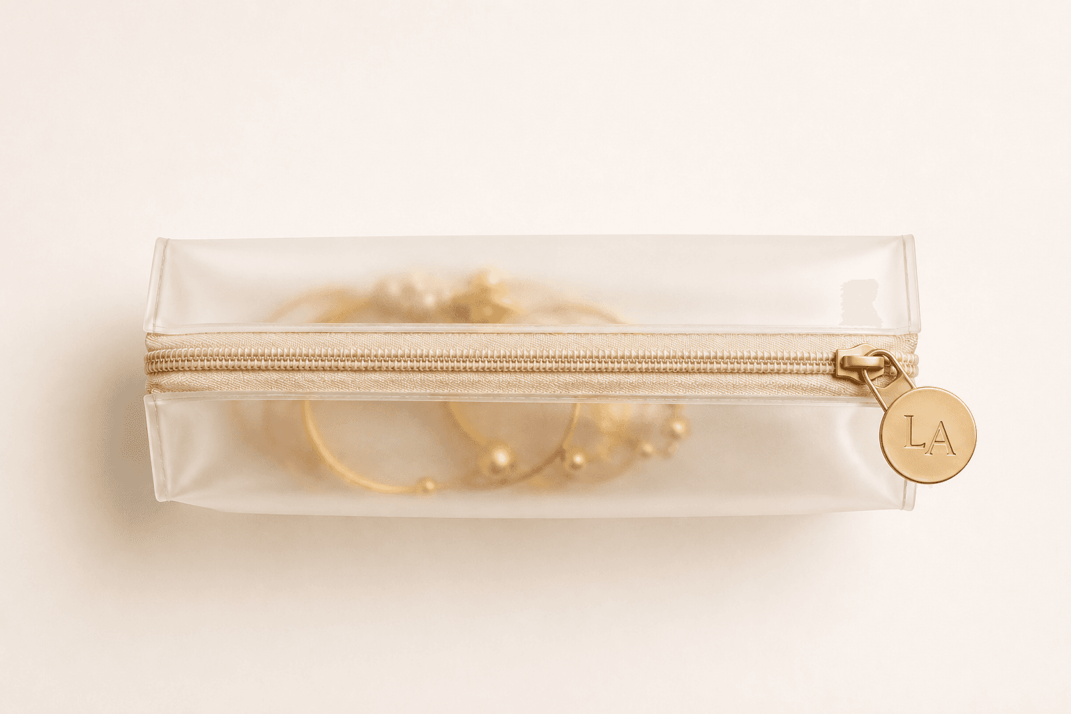 La Asena transparent jewelry pouch with gold monogram charm